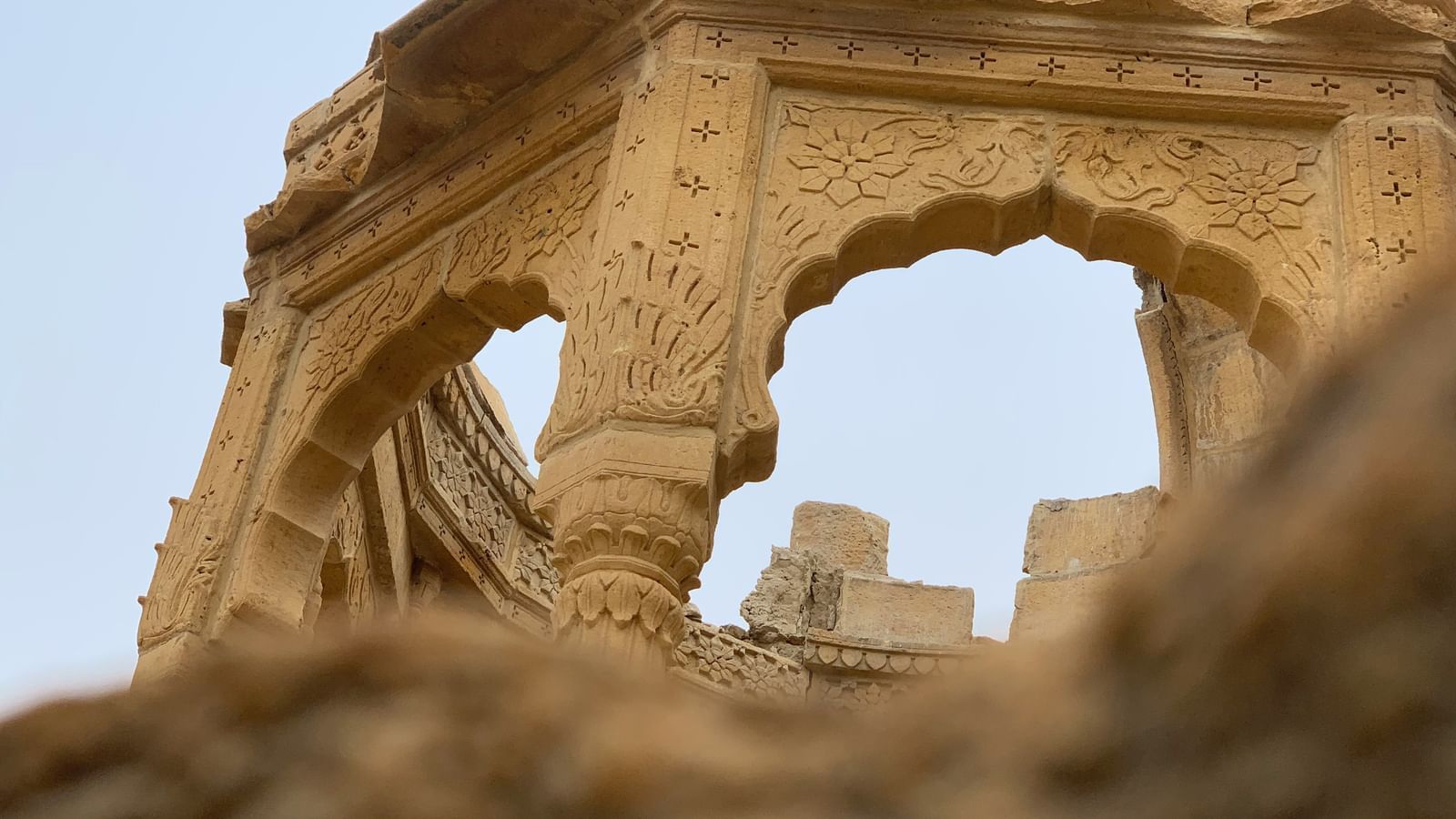 a view from below of a fort with intricate architecture with a clear blue sky in the background