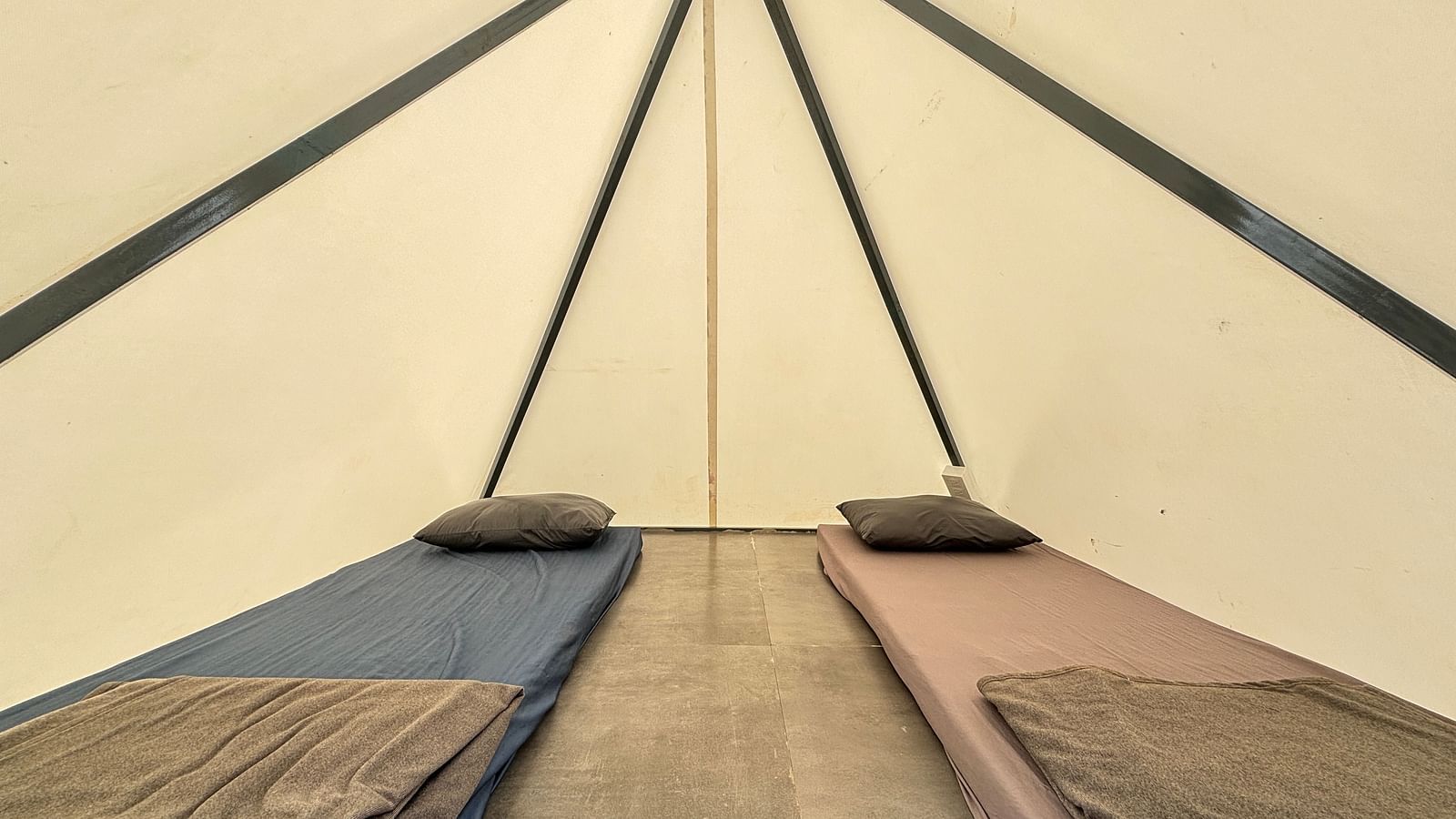 Interior of a spacious tent featuring neatly arranged sleeping mats, offering a comfortable sleeping arrangement for guests.