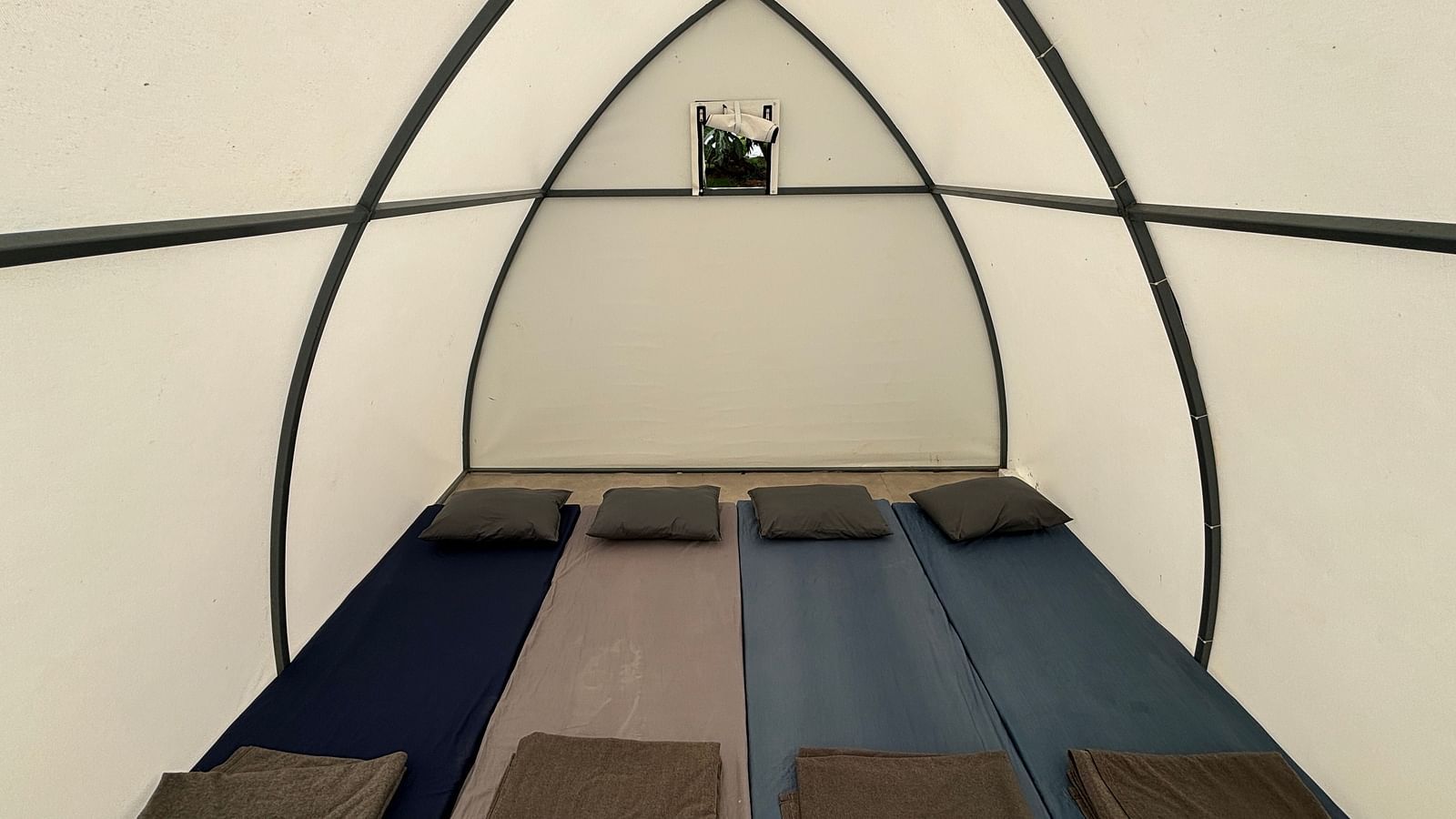 Interior of a spacious tent featuring neatly arranged sleeping mats, offering a comfortable sleeping arrangement for guests.