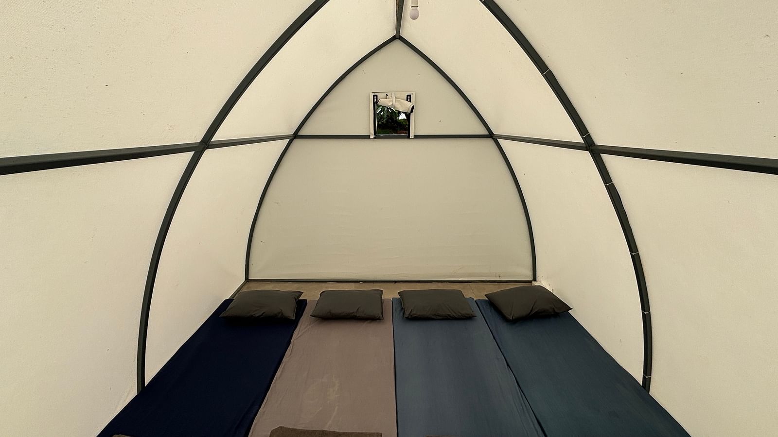 Interior of a spacious tent featuring neatly arranged sleeping mats, offering a comfortable sleeping arrangement for guests.