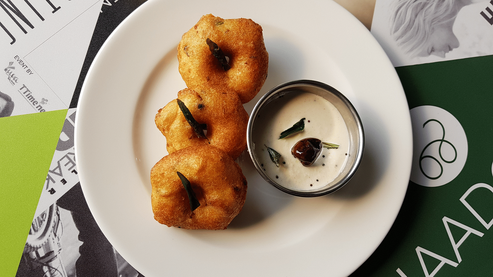 vada and chutney platted on a white plate and kept on a table