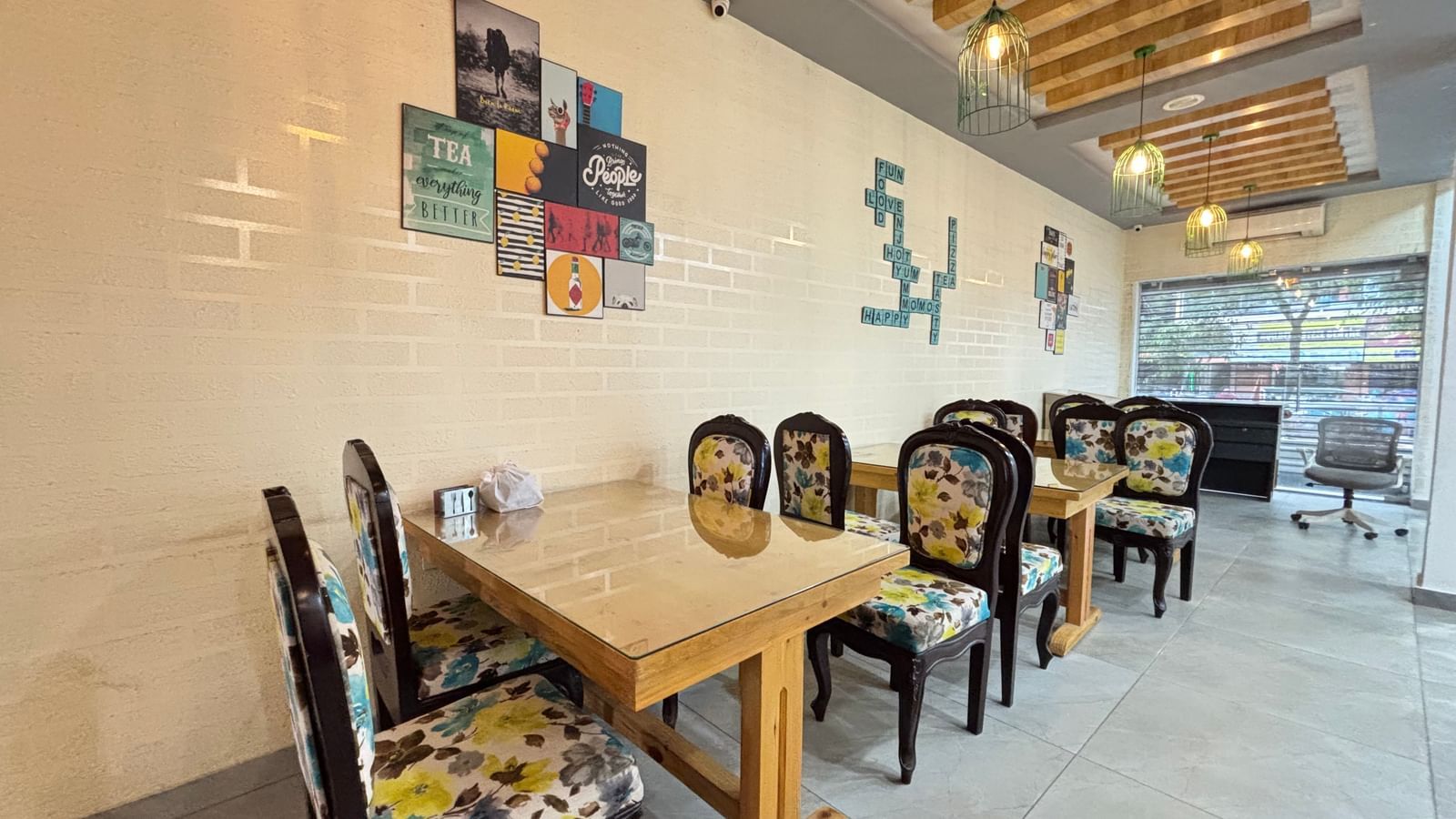 Tables and chairs arranged for dining, bright interior with artwork on walls at Sumitel Premier Inn.