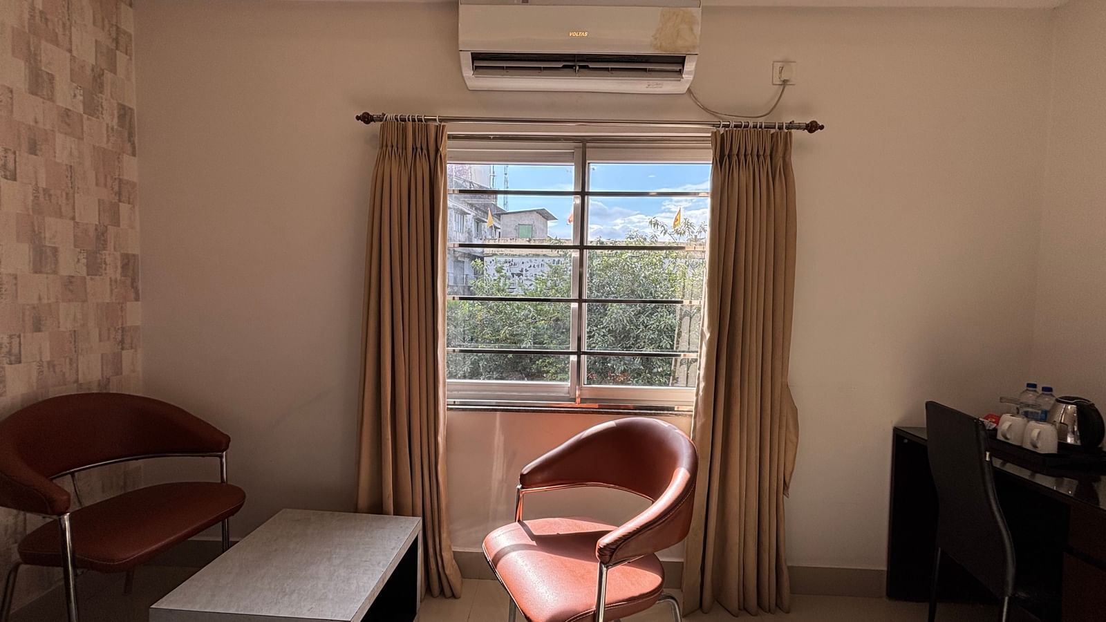 Seating area in a hotel room with two chairs, a table, and a window at Sumitel Premier Inn.
