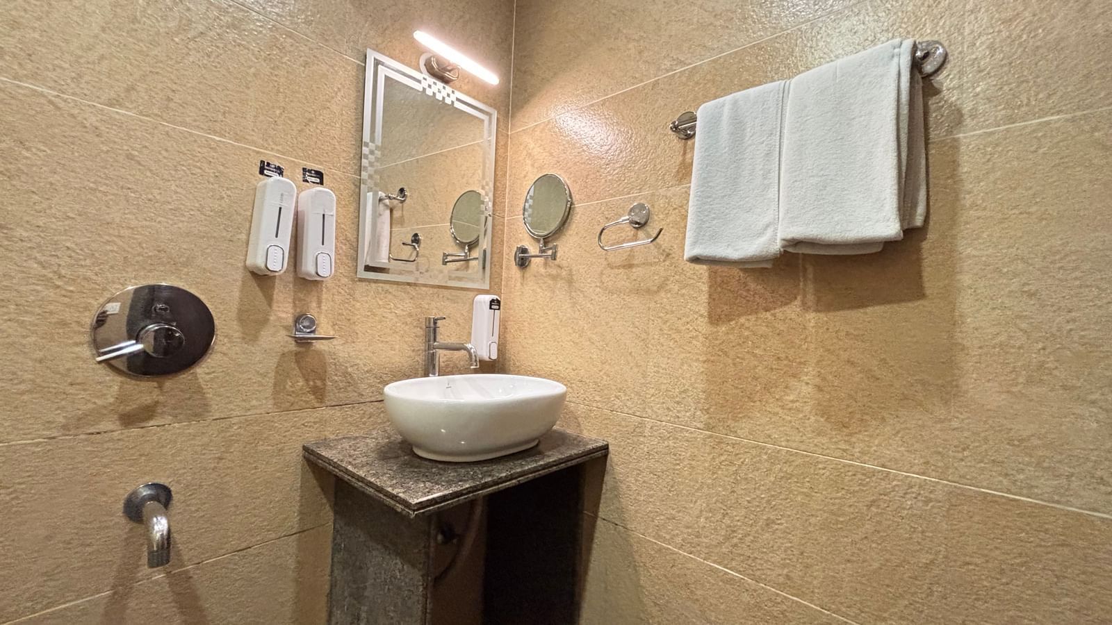 Well-appointed bathroom at Sumitel Premier Inn with sink, mirror, and towel rack.