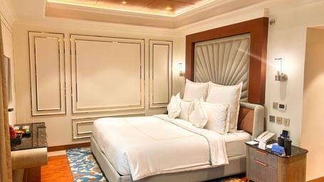 King-size bed in a room with accent wall panelling and warm lighting at Accord Metropolitan.