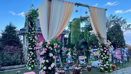 Outdoor mandap arrangement at Cedar Inn, Darjeeling, set on the lawn with mountain views and floral arch backdrop.