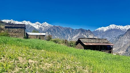 Image of a valley with huts and majestic mountians in the background | Faraway Cottages, Auli