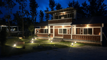Hatti Eden Coorg | An illuminated facade with trees and sky in the backdrop at night.
