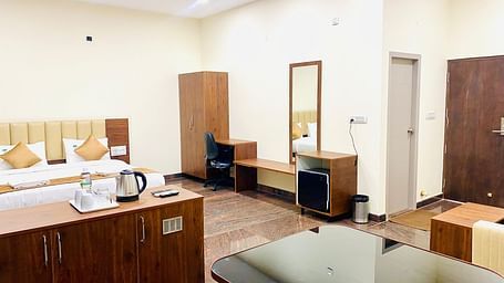 This spacious room at Hotel Sahara Tree includes a bed, wardrobe, and dressing table.