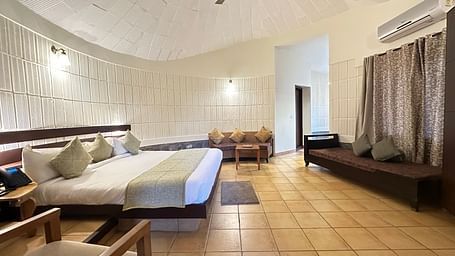 a bedroom with a double bed and a single bed opposite to it, with chairs in the room - Kadkani River Resort, Coorg