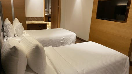 A top Premium Twin room  shot with cosy bed, TV at SRM Hotel Maram Malai Nagar, Chennai