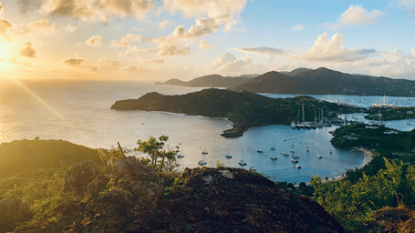 Aerial view of a tropical bay with islands, mountains, and golden sunset light