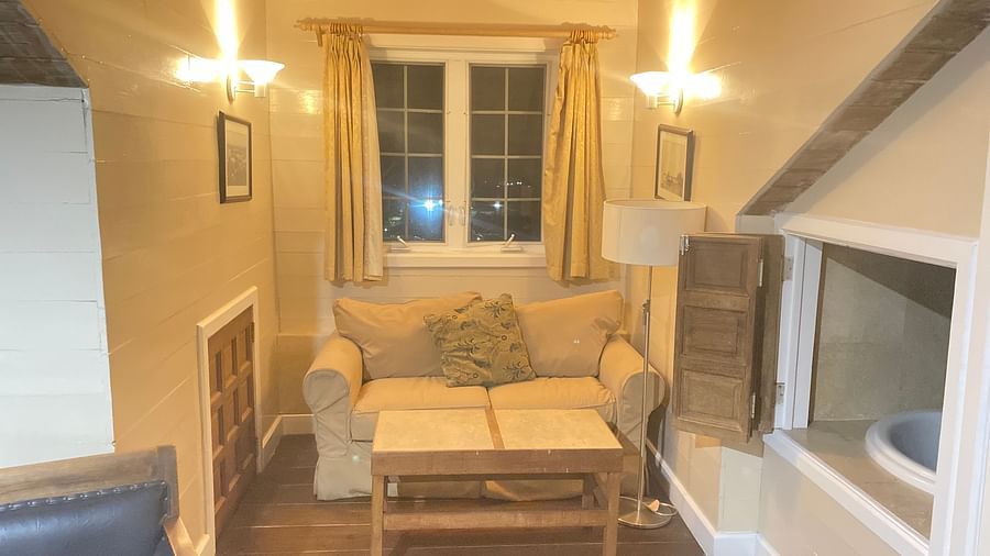 Cozy room with a sofa, a small table, and sloped wooden ceiling | A Stone's Throw Away