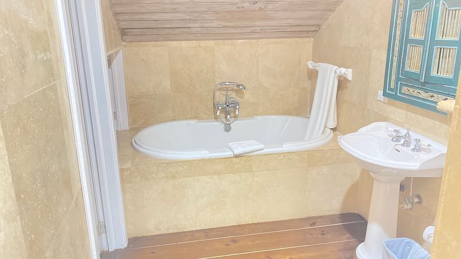 A bathroom with a freestanding bathtub under a sloped ceiling | A Stone's Throw Away