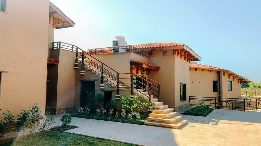 A cluster of beautifully designed resort buildings with outdoor staircases at Aamaghati Wildlife Resort.