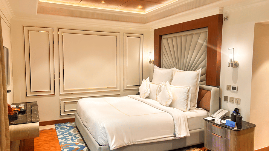 A well-decorated bed in a room with accent wall panelling and warm lighting at Accord Metropolitan.