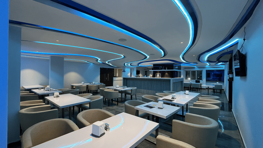 Contemporary bar seating area with curved lighting design at Alps Residency, Krishnagiri.