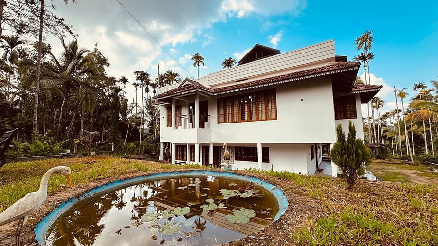 Image of the Facade of Ananda Holiday Home, Wayanad on a bright day wit a pond in front of it