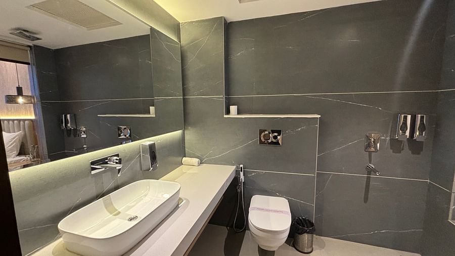 Modern bathroom with sleek grey tiles, a wall-mounted sink, and toilet –  ARNISA Boutique Hotel