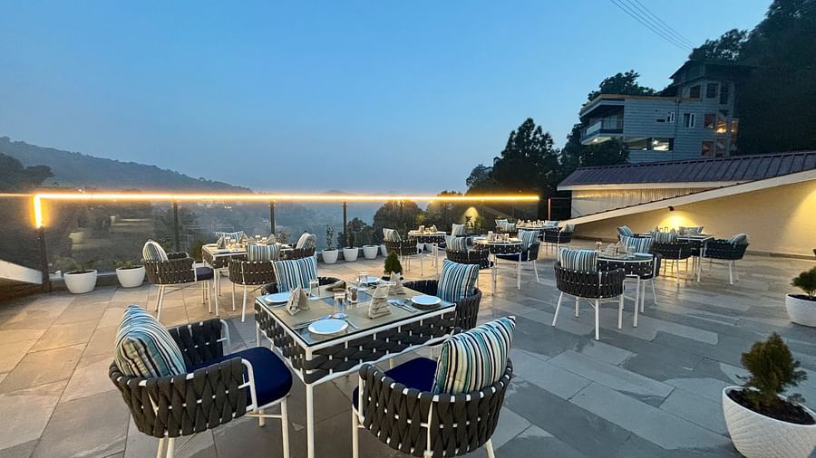 Outdoor dining area at twilight with neatly arranged tables and scenic views – ARNISA Boutique Hotel