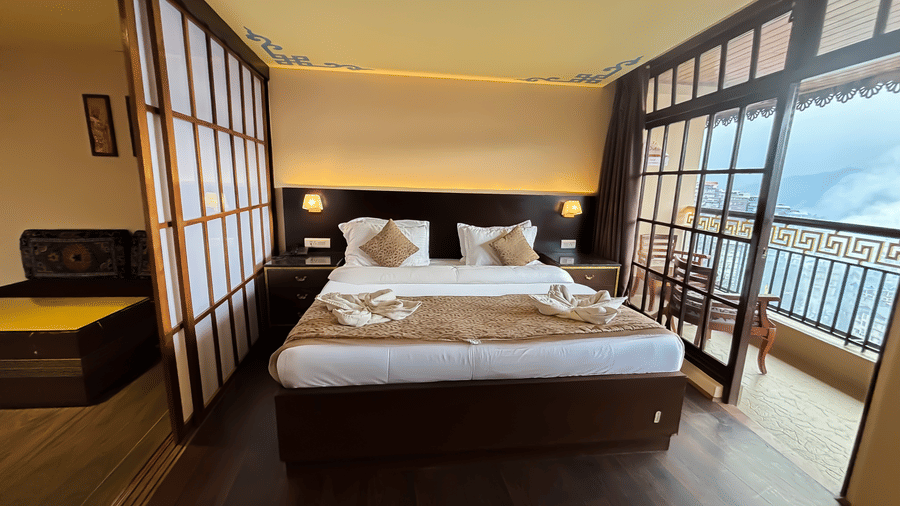 Bedroom with a balcony offering mountain views at Avianna Hungry Jack, Gangtok.