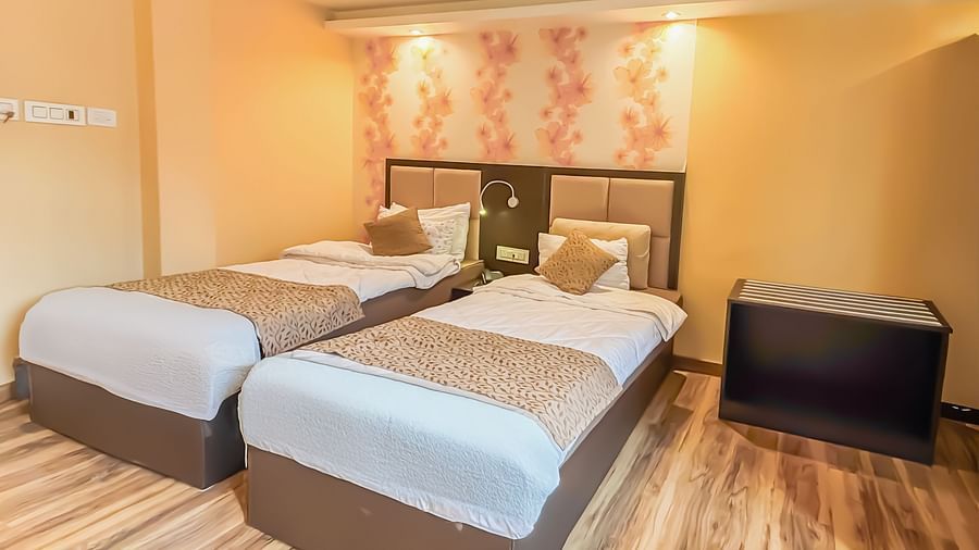 Twin beds with a decorative painting behind the headboard at Avianna Hungry Jack, Gangtok.