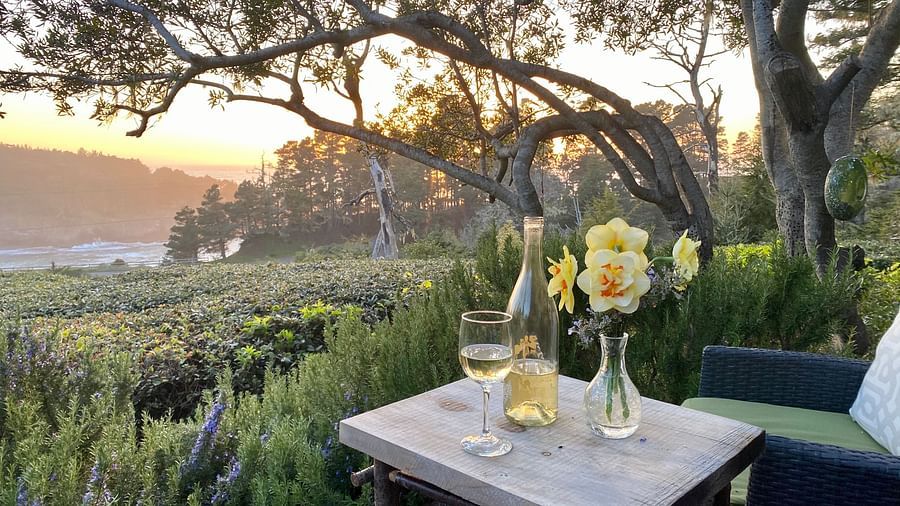 A cozy outdoor seating area overlooking the ocean at sunset - Brewery Gulch Inn & Spa