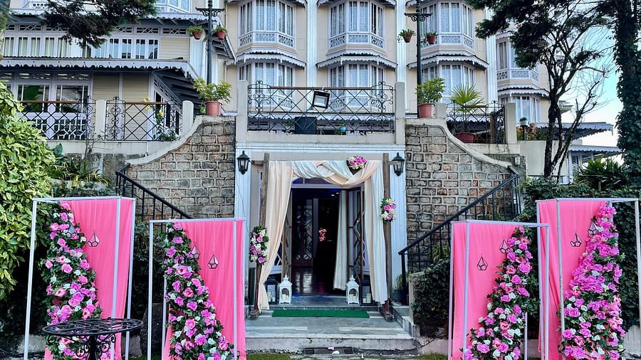 Wedding entrance decor at Cedar Inn, Darjeeling, showcasing the lawn area with floral arrangements and the property's charming exterior.