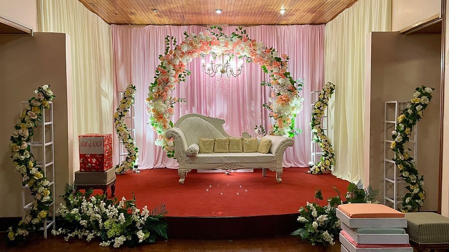 Indoor wedding stage setup at Cedar Inn, Darjeeling, with floral arch, stage seating, and draped backdrop for ceremonies.