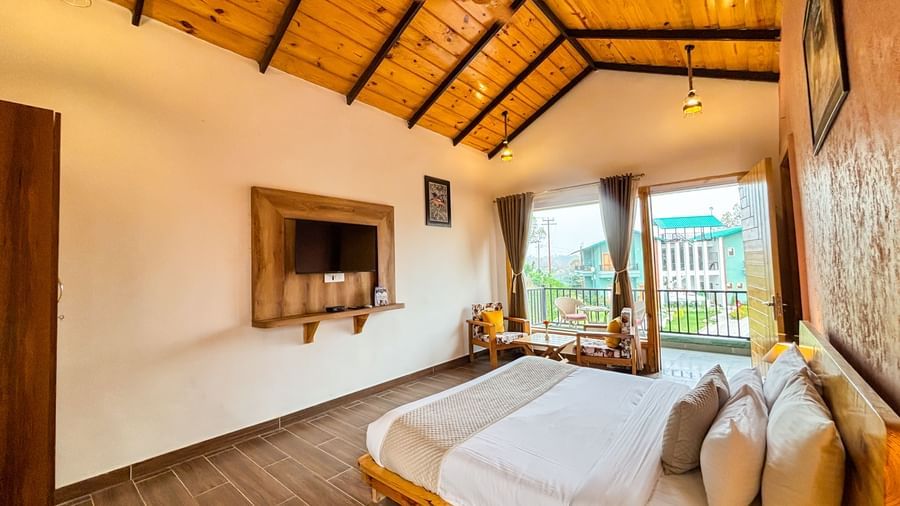 Bright resort room with wooden ceiling, modern decor, and large windows offering scenic views.