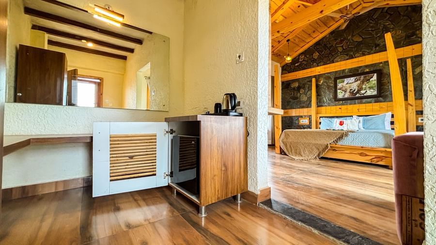 Resort room with open layout, wooden flooring, and stylish furniture at Corbett Nirvana Resort.