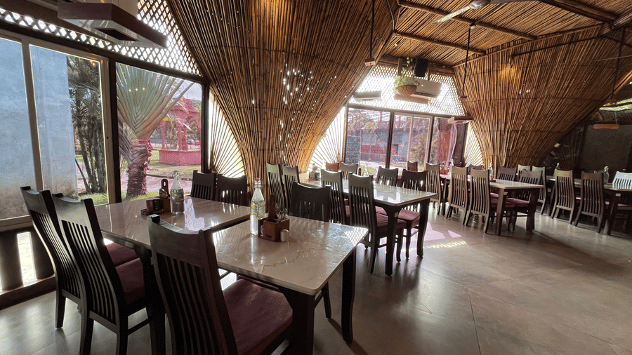 Spacious multi-cuisine restaurant with rustic bamboo decor and large glass windows - DAN Resorts & Weddings, Palghar