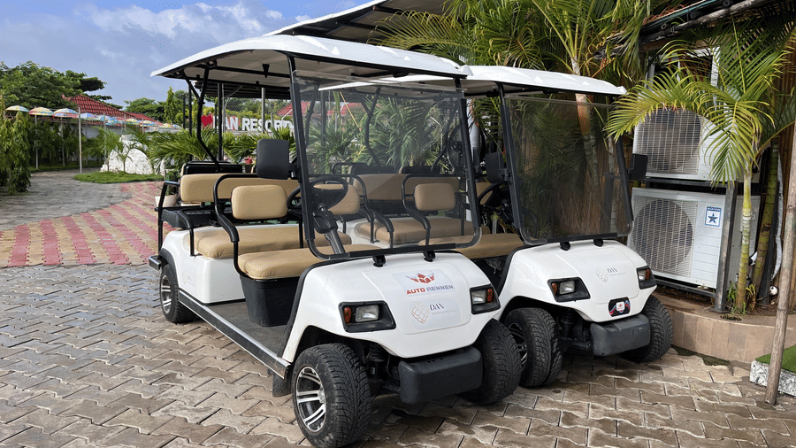 Pair of white electric golf carts used for guest transportation around the property - DAN Resorts & Weddings, Palghar