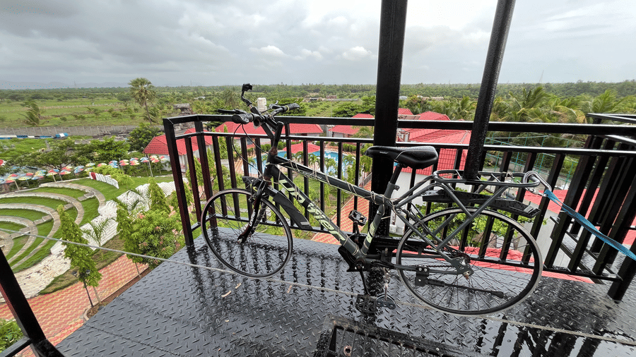 High-altitude sky cycling station with a bicycle mounted on a wire overlooking the landscape - DAN Resorts & Weddings, Palghar
