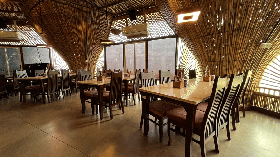 Main dining area featuring unique inverted bamboo cone structures and wooden tables - DAN Resorts & Weddings, Palghar