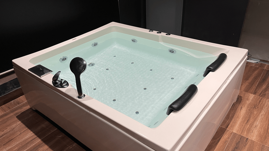 Luxury indoor jacuzzi tub set up with wine glasses for a romantic stay - DAN Resorts & Weddings, Palghar