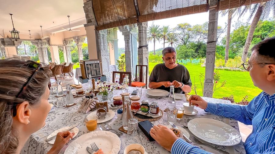 image of a group of three people having brunch at Dev Shree, Deogarh overlooking a lush green lawn