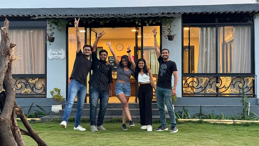 Group of friends posing joyfully in front of a hostel at sunset | Diamond Parks, Pune.