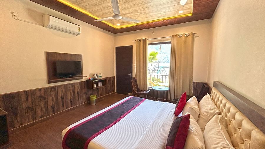 A Luxury Cottage with a large bed in front of the TV at DLS MJ River Resort, Rishikesh.