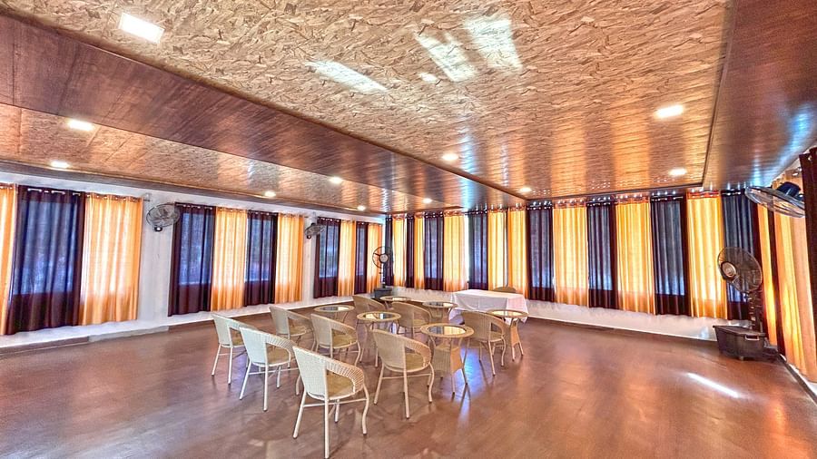 A conference hall with ambient lighting and chairs facing the stage at DLS MJ River Resort, Rishikesh.