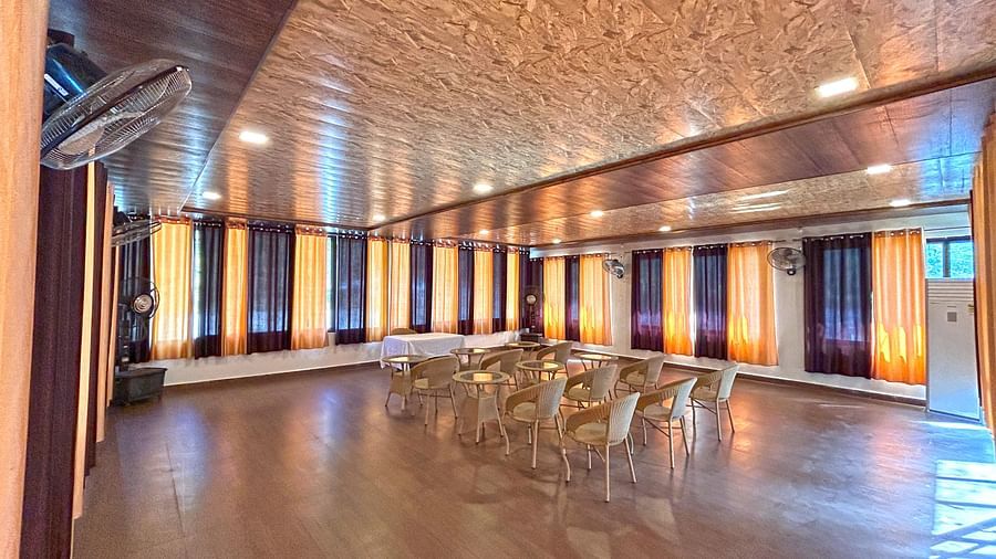 A conference hall with ambient lighting and chairs facing the stage at DLS MJ River Resort, Rishikesh.