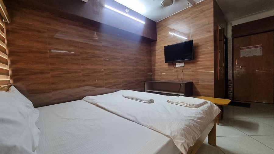Full view of the bedroom at the Dream Vision Guest House facing towards a wall mounted television.