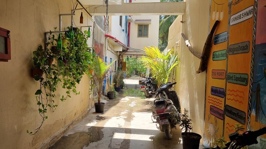 Entrance corridor at the Dream Vision Guest House with several two wheeler vehicles parked in the corner.