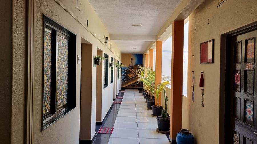 An expansive brightly lit corridor at the Dream Vision Guest House with cream coloured walls.