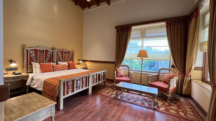  A comfortable Superior Lake Facing Room at Fishermen's Lodge, Bhimtal, featuring a wide open window with stunning views of the lake and surroundings.
