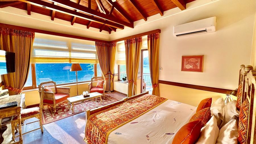A comfortable Superior Lake Facing Room at Fishermen's Lodge, Bhimtal, with an open window allowing sun rays to illuminate the space.