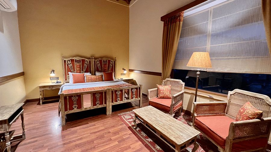 Superior Lake Facing Rooms featuring a closed window with curtains, a comfy bed, chair, and table, creating a cozy atmosphere- Fishermen's Lodge, Bhimtal 