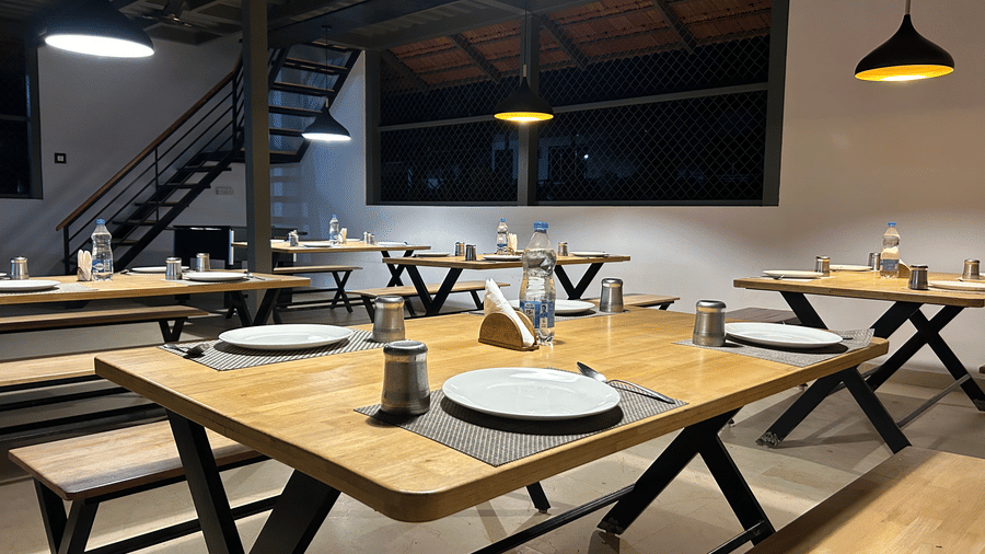 A dining area at Hatti Eden Coorg, with tables and chairs set for dining.