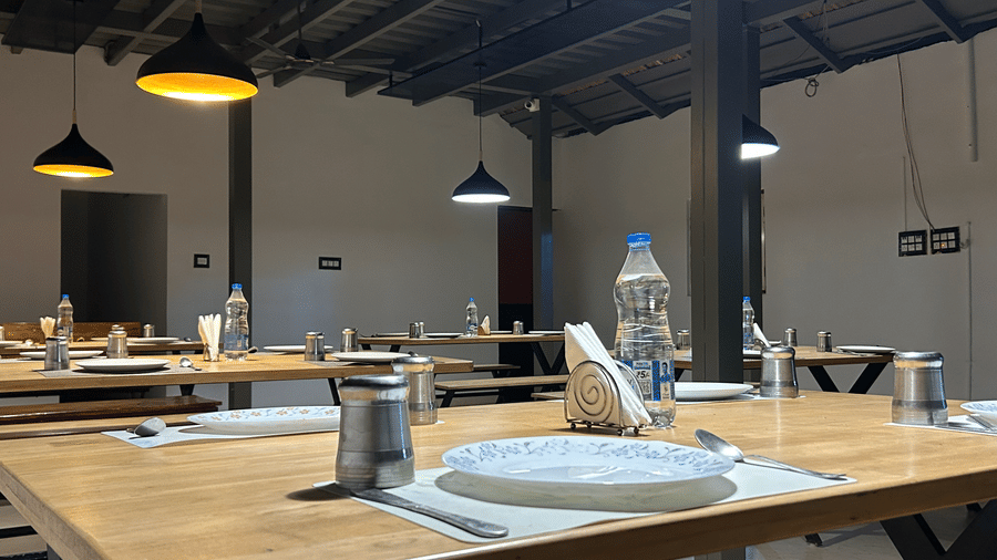 Dining space at Hatti Eden Coorg, with tables and chairs set for dining.