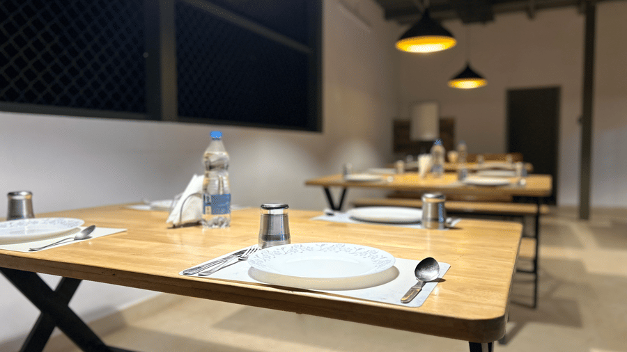 A dining area at Hatti Eden Coorg, with tables and chairs set for dining.